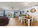 Casual dining area with a farmhouse table and chairs, adjacent to the living room at 29836 69Th N Way, Clearwater, FL 33761