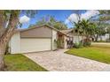 Well-maintained house featuring a large yard and a brick paved driveway at 3005 Enisglen Dr, Palm Harbor, FL 34683