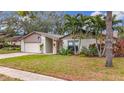 Charming one-story house with lush landscaping and a brick driveway at 3005 Enisglen Dr, Palm Harbor, FL 34683