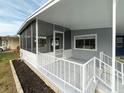 Mobile home with screened porch and white railing at 36905 Kay Ave, Zephyrhills, FL 33542