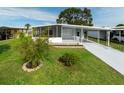 Mobile home with carport, screened porch, and landscaped lawn at 36905 Kay Ave, Zephyrhills, FL 33542