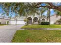 Two story house with a three-car garage and lush landscaping at 4337 Waterford Landing Dr, Lutz, FL 33558