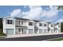 Row of modern townhomes featuring light gray siding, blue shutters, and single-car garages, under a bright sky at 4648 Pleasant Ave, Palm Harbor, FL 34683