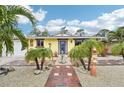 Bright yellow house with a red brick pathway and palm trees at 5780 Elton Rd, Venice, FL 34293