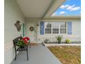 Inviting front porch with a bench and colorful flowers at 5871 49Th N Ave, Kenneth City, FL 33709