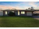 Evening view of a charming ranch home with a green lawn at 6512 2Nd Ave Ne, Bradenton, FL 34208