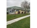 Ranch-style home with green roof, sidewalk, and lawn at 102 Cambridge Trl # 229, Sun City Center, FL 33573