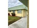 Building exterior showcasing a light yellow facade and green roof at 102 Cambridge Trl # 229, Sun City Center, FL 33573