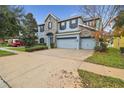 Two-story house with stone and blue siding, three-car garage, and driveway at 10825 Charmwood Dr, Riverview, FL 33569