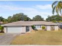 Single-story home with attached garage and landscaped yard at 13561 105Th Ave, Largo, FL 33774