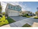 Two-story house on a tree-lined street with a gray garage door and manicured lawn at 4456 Tubular Run, Land O Lakes, FL 34638