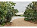 Inviting pathway meanders through lush tropical landscaping toward waterfront at 5027 Sunrise S Dr, St Petersburg, FL 33705