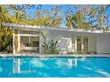 Stunning pool view of a mid-century modern home with lush landscaping at 5027 Sunrise S Dr, St Petersburg, FL 33705