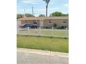 Tan single-story house with white picket fence and small front yard at 6502 W Clifton St, Tampa, FL 33634