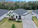 One-story home with gray exterior, landscaping, and a paved driveway at 7532 Ashbrooke Pine Loop, Odessa, FL 33556