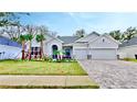 One-story home with gray siding, landscaping, and a paved driveway at 7532 Ashbrooke Pine Loop, Odessa, FL 33556