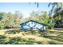 Back view of house with large yard and trees at 8615 Greenfield Ln, Zephyrhills, FL 33541