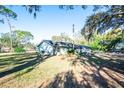 Side view of house with a large yard and trees at 8615 Greenfield Ln, Zephyrhills, FL 33541