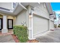 Townhome exterior featuring a two-car garage and entryway at 9715 Taylor Rose Ln # 9715, Seminole, FL 33777