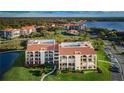 Condo building with surrounding landscape and water at 102 Mariner Dr, Tarpon Springs, FL 34689