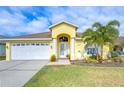 Bright yellow house with white garage door and landscaping at 11511 Lounds Ct, New Port Richey, FL 34654