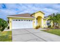 Front view of a yellow house with a white garage door at 11511 Lounds Ct, New Port Richey, FL 34654