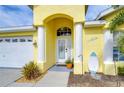 Front entry with columns, decorative door, and coastal accents at 11511 Lounds Ct, New Port Richey, FL 34654