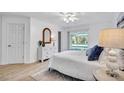 Bedroom with a slider to the pool area, a bright window, and light-colored wood flooring at 11624 Monette Rd, Riverview, FL 33569