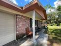 Brick home with a covered porch and a chair, needs some maintenance at 14810 N 30Th St, Lutz, FL 33559