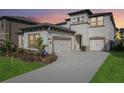 Two-story house with a three-car garage and landscaped front yard at 14838 Paddock Pond Ave, Lithia, FL 33547