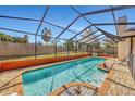 Screened-in pool features brick surround, bright orange trim and a beautiful, clear blue water at 1803 Tawnee Pl, Brandon, FL 33510