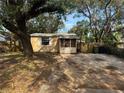 Quaint yellow house with screened porch and gravel driveway at 2008 E Annie St, Tampa, FL 33612