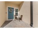 Inviting front entry with teal door and cozy seating at 29913 Southwell Ln, Wesley Chapel, FL 33543