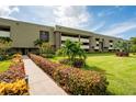 Building exterior showcasing manicured lawn and walkway at 36750 Us Highway 19 N # 04221, Palm Harbor, FL 34684