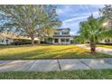 Inviting two-story home with lush green lawn, mature trees, and a long driveway at 3870 155Th E Ave, Parrish, FL 34219