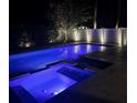 Night view of a backyard pool and spa with blue lighting at 4224 W Kensington Ave, Tampa, FL 33629