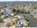 Aerial view of waterfront home with pool, lush landscaping, and neighborhood with views of the city skyline at 4801 Venetian Ne Pl, St Petersburg, FL 33703