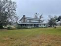 Two-story house with a wraparound porch and large grassy yard at 5007 Booth Rd, Plant City, FL 33565