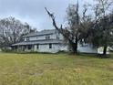 Two-story house with a wraparound porch, large yard, and storage container at 5007 Booth Rd, Plant City, FL 33565