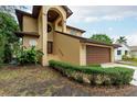 Two-story house with a brown garage door and well-manicured hedges at 513 Suwanee Cir, Tampa, FL 33606