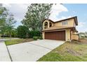 Two-story house with brown garage door and a fountain in the front yard at 513 Suwanee Cir, Tampa, FL 33606