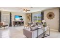 Spacious living room with gray sofas, a large TV, and plenty of natural light at 5322 Oxford Gray Rd, Wesley Chapel, FL 33545