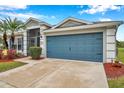 Gray house with blue garage door and well-maintained landscaping at 5720 107Th E Ter, Parrish, FL 34219