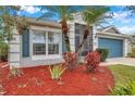 Landscaped front yard with palm trees and red mulch at 5720 107Th E Ter, Parrish, FL 34219