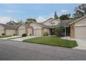 Tan two-story home with brick accents, landscaped lawn, and attached garage at 6432 Remus Dr, New Port Richey, FL 34653