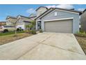 Two-story house with gray exterior, two-car garage, and landscaping at 656 Argyll Dr, Spring Hill, FL 34609