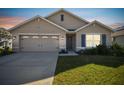 Tan house with a two-car garage and landscaped lawn at 12143 Kingsley Trl, Parrish, FL 34219