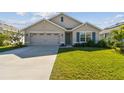 Tan house with a two-car garage and landscaped lawn at 12143 Kingsley Trl, Parrish, FL 34219