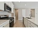 Modern kitchen with white cabinets, stainless steel appliances, and quartz countertops at 2416 Wise River Ln, Zephyrhills, FL 33541