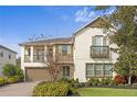 Two-story house with balcony, stone accents, and landscaping at 28475 Marsciano Ln, Wesley Chapel, FL 33543